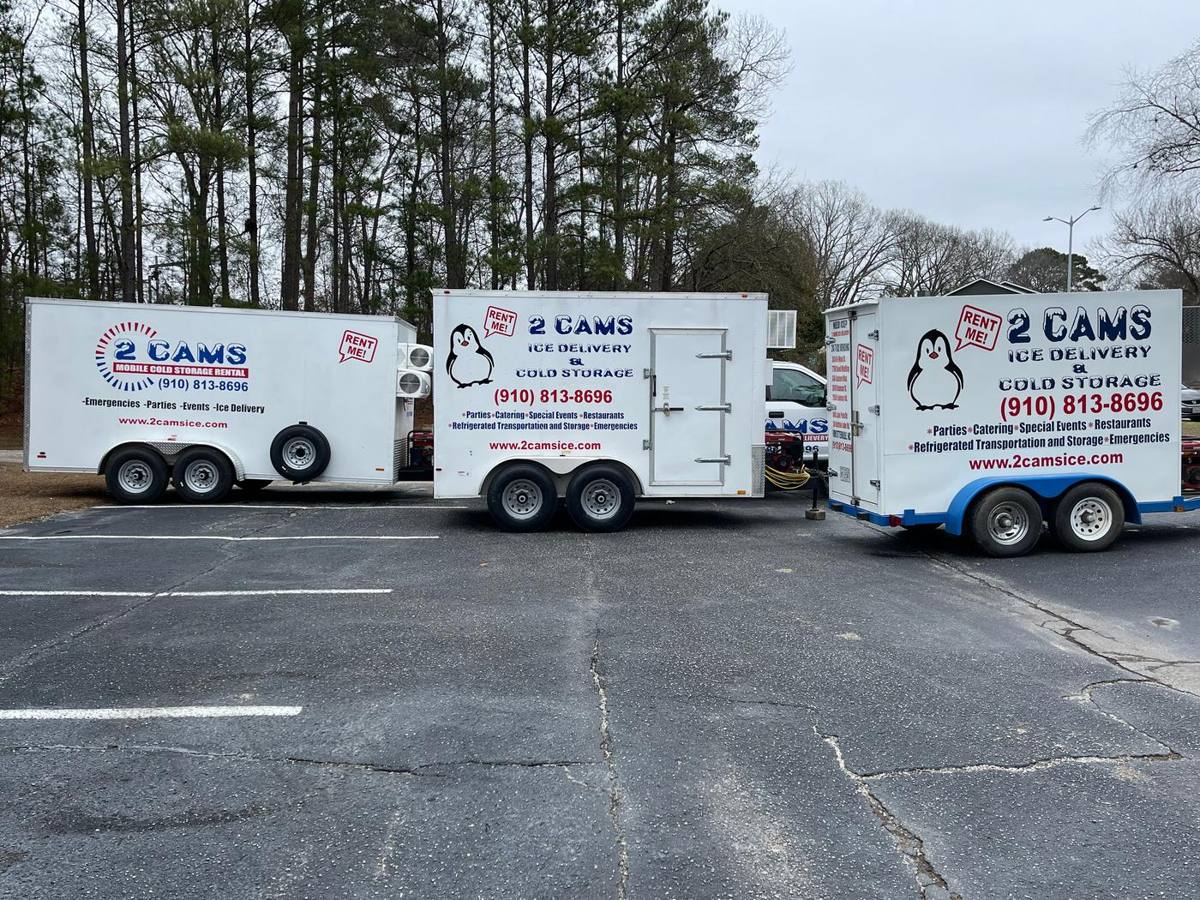 Three 2 Cams Ice refrigerated trailers lined up in a parking lot, showing (910) 813-8696