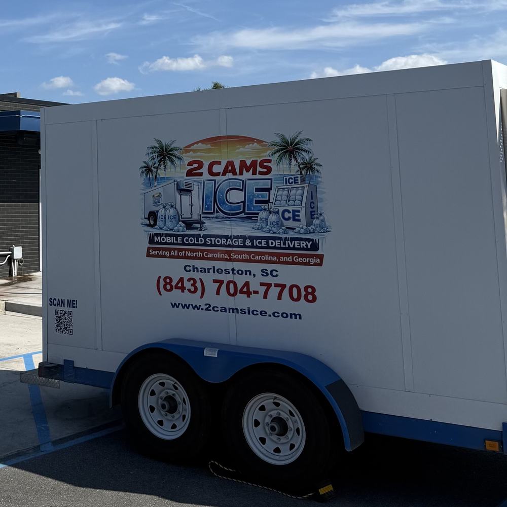 2 Cams Ice refrigerated trailer with the palm-tree logo and (843) 704-7708 on the side, parked on site in Charleston, SC