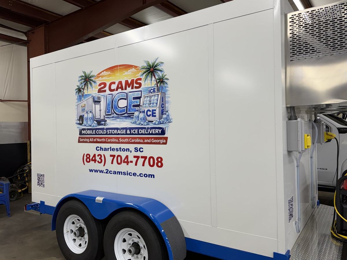 White 2 Cams Ice refrigerated trailer with a blue frame and the South Carolina palm-tree logo, side view