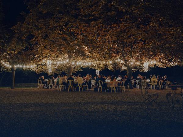 Outdoor wedding reception under string lights, supplied with event ice delivery