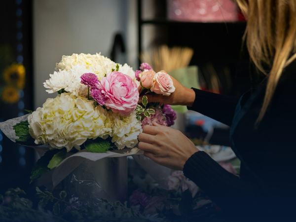 Florist arranging a fresh bouquet, kept fresh in a refrigerated trailer rental