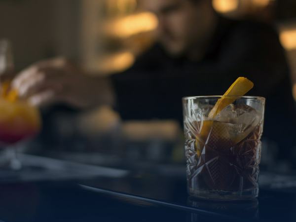 Bartender mixing drinks at a busy restaurant bar that needs daily bagged ice delivery
